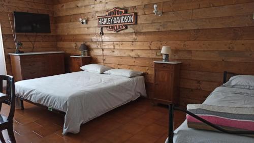 two beds in a room with wooden walls at Casa Olmi in Castiglione dʼIntelvi