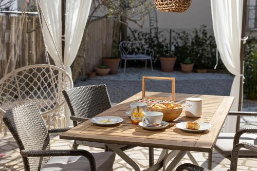 una mesa de madera con tazones de comida en el patio en Apartment Levante, en Crikvenica