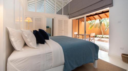 a bedroom with a bed with blue and white pillows at Maya Tangalle in Tangalle