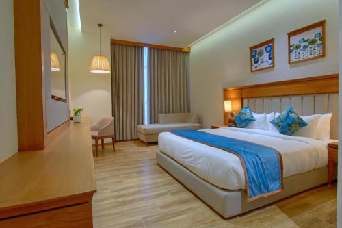 a hotel room with a large bed and a chair at Sayaji Morbi in Morbi