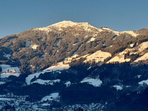 a snow covered mountain with a town in front of it at Ferienwohnung Rose in Hart im Zillertal