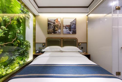 a bedroom with a large bed and an aquarium at Nostalgia S Hotel - Olympic Sports Center in Beijing