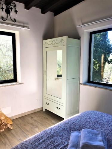 a bedroom with a bed and two windows at Casale l'Antica Mola in Castel Madama