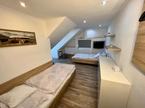 Habitación pequeña con 2 camas y cocina en Rabbit apartman, en Mosonmagyaróvár