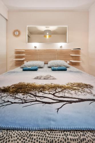 une chambre avec un grand lit avec des oreillers bleus dans l'établissement Les 2 Freres - Residence la fontaine Les Sablettes, à La Seyne-sur-Mer