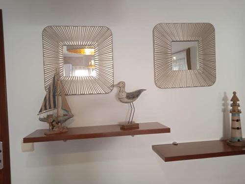 two mirrors on a shelf with a bird on it at Orlanda Veríssimo in Nazaré