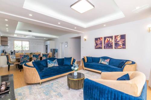 a living room with blue couches and a table at Home Sweet Home in Nairobi
