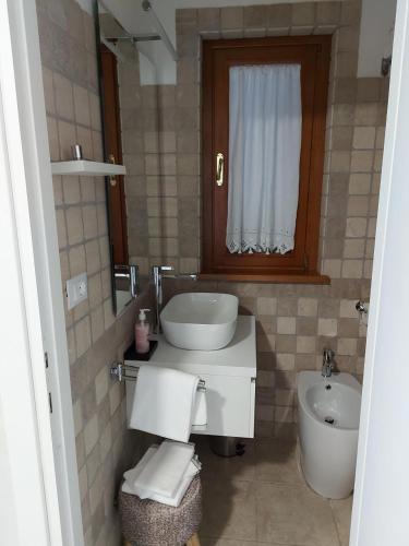 a bathroom with a sink and a toilet and a window at B&B Ferro di Cavallo in Tivoli