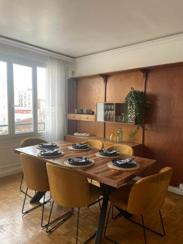 a dining room with a wooden table and chairs at magnifique appartement in Paris