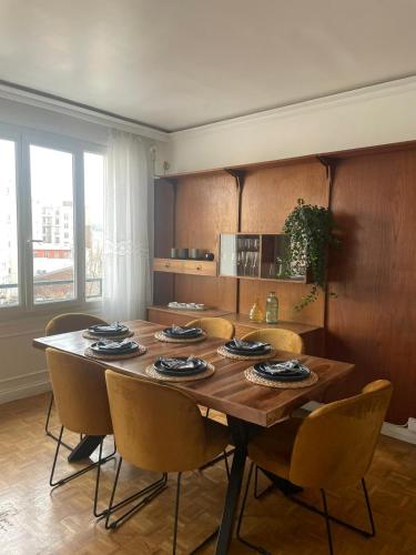 une salle à manger avec une table et des chaises en bois dans l'établissement magnifique appartement, à Paris