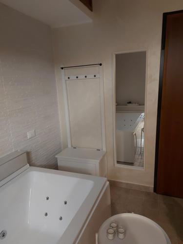 a white bathroom with a toilet and a mirror at B&B Ferro di Cavallo in Tivoli