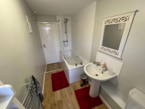 a white bathroom with a sink and a tub and a toilet at Charming Countryside Cottage Ground Floor Apartment in Combeinteignhead Devon in Bishopsteignton