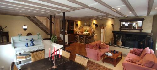 - un salon avec des chaises roses et une cheminée dans l'établissement Gites du Domaine du Petit Moulin, à 15 min de la mer, D-Day, nature et calme, idéal famille, à Courcy