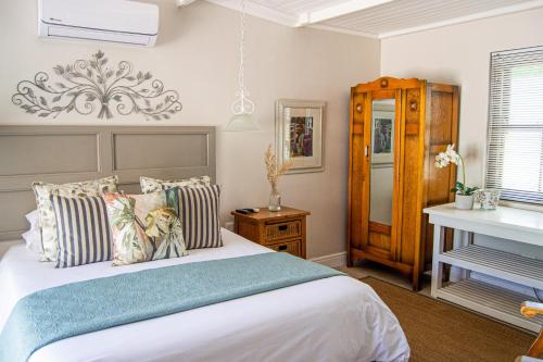 a bedroom with a large bed and a piano at Madeliefie Guest Accommodation in Paarl