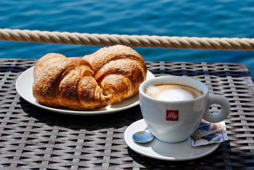 a cup of coffee and two pastries on a table at Tre Merli Beach Hotel in Trieste