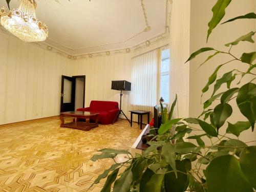 a living room with a red couch and a chair at DAY & NIGHT in Odesa