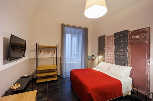 a bedroom with a red bed and a flat screen tv at The Bellini House by House In Naples in Naples