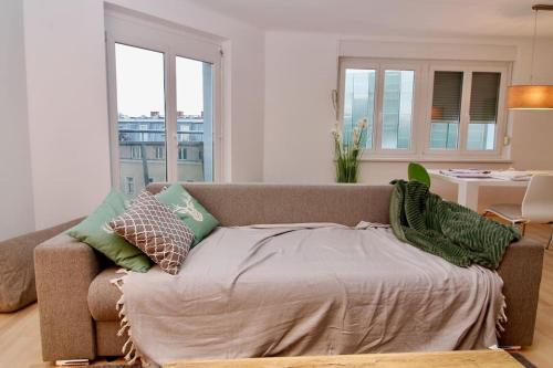 een woonkamer met een bank met kussens erop bij Graz central Penthouse Style Apt in Graz