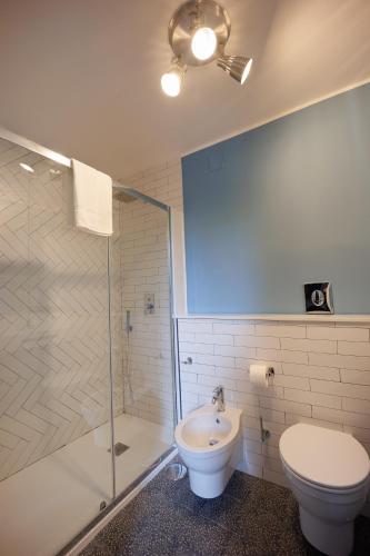 a bathroom with a toilet and a glass shower at The Bellini House by House In Naples in Naples