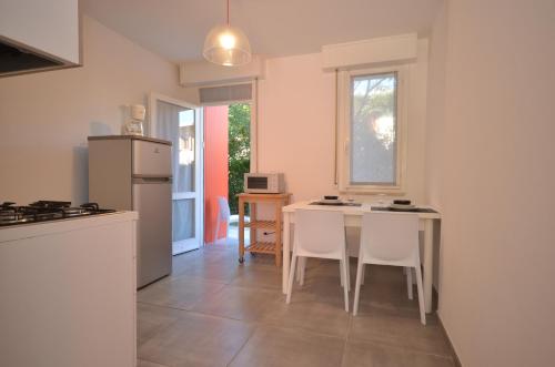 a kitchen with a table and chairs and a refrigerator at Appartamenti Villa Simona in Bibione
