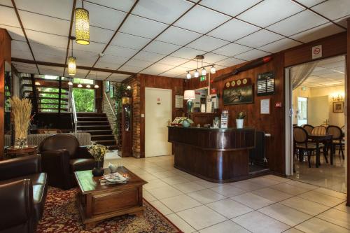 a lobby of a restaurant with a bar at Aerotel Versailles Saint Cyr - L'étape du Silence in Saint-Cyr-lʼÉcole