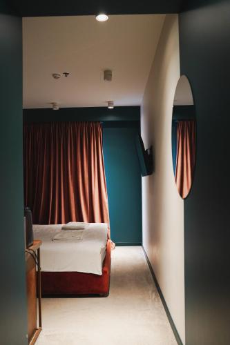a bedroom with a bed and a red curtain at About Sololaki in Tbilisi City