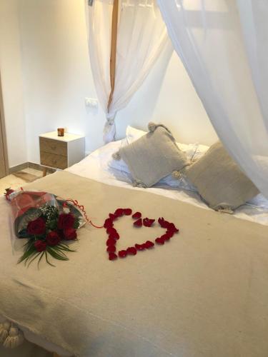 un corazón hecho de rosas en una cama en Studio La Boheme Jacuzzi et Terrasse vu sur Pic Saint Loup, en Prades-le-Lez