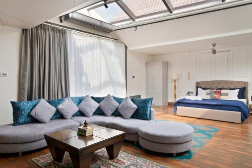 uma sala de estar com um sofá e uma cama em The Moira - Bed and Breakfast em Calcutá