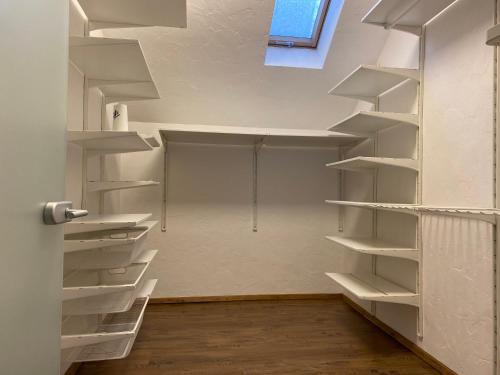 ein leerer Schrank mit weißen Regalen in einem Zimmer in der Unterkunft Apartment Chalet mit Kamin in Plauen