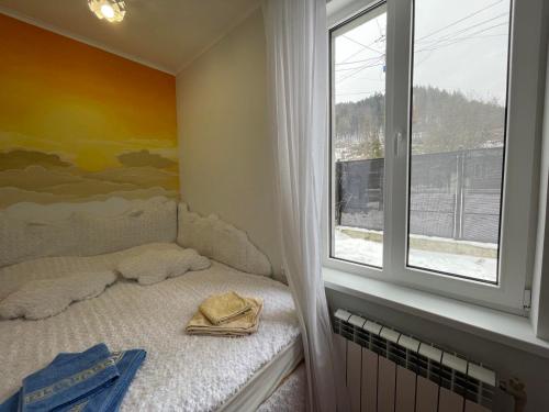 a small bedroom with a bed and a window at Чотири стихії in Mizhhirʼʼya