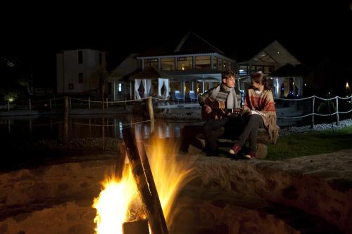 two people sitting around a fire at night at Aranwa Pueblito Encantado del Colca in Coporaque