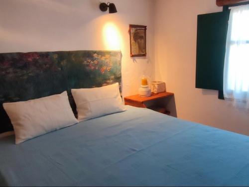 um quarto com uma cama com um quadro na parede em PATELO HOUSE em Agia Marina