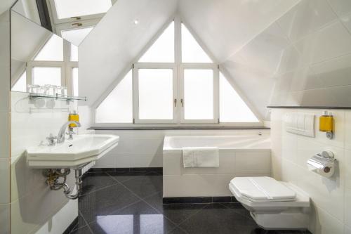 a white bathroom with a sink and a toilet at Black Star Suites in Prague