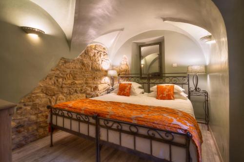 uma cama num quarto com uma parede de pedra em Black Star Suites em Praga