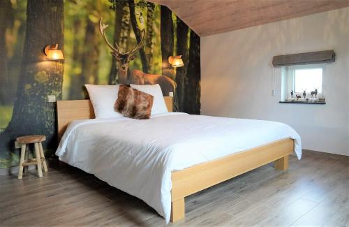 a bedroom with a large bed with a deer mural at "Petite perle en Haute Ardenne" avec vue sur la vallée, cabine infra-rouge et bain balnéo in Lierneux