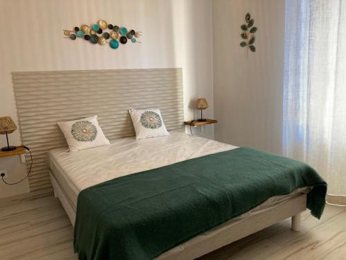 ein Schlafzimmer mit einem Bett mit einer grünen Decke darauf in der Unterkunft Villa sept fonds in Royan