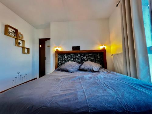 - une chambre avec un grand lit bleu et deux oreillers dans l'établissement Superbe appartement cosy, à Annecy