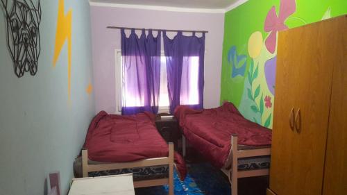 um pequeno quarto com 2 camas e uma janela em Cuyén Hostel em Villa María