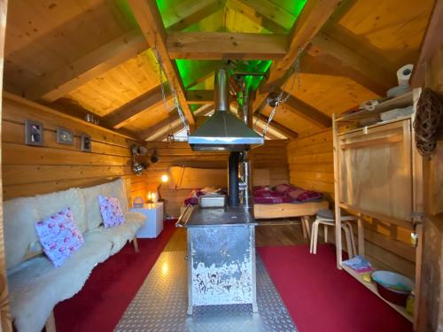 una habitación con sofá y estufa en una cabaña en Schwarzwald Romantikhütte *kuschelig *einzigartig en Schenkenzell