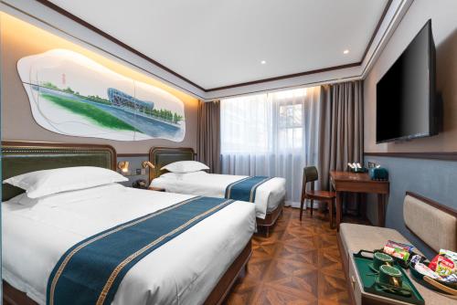 Habitación de hotel con 2 camas y TV de pantalla plana. en Nostalgia Hotel University of Science and Technology Beijing en Pekín