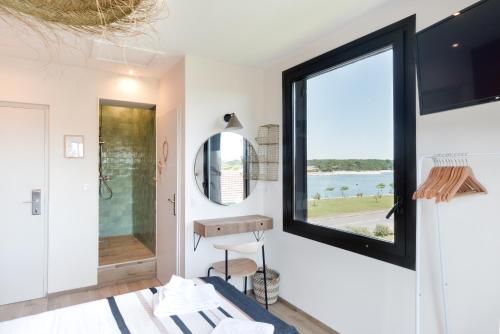 a bathroom with a large window and a sink at Single Fin Hotel & Lodge in Mimizan-Plage