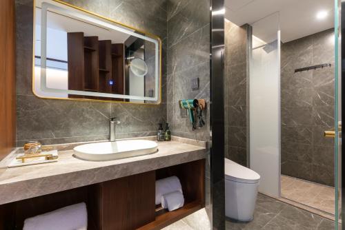 a bathroom with a sink and a mirror and a toilet at Nostalgia S Hotel Beijing National Stadium-Bird's Nest 时光漫步S酒店北京科技大学鸟巢店 Free fresh ground coffee,Free laundry service in Beijing