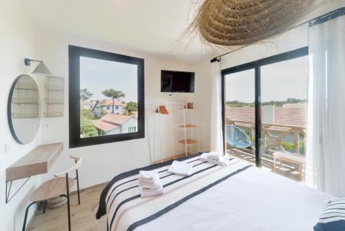 a bedroom with a bed and a large window at Single Fin Hotel & Lodge in Mimizan-Plage