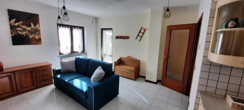 een woonkamer met een blauwe bank en een stoel bij A casa di Vera - Vivi la tua Valle d'Aosta in Nus