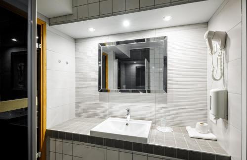 y baño con lavabo y espejo. en Hotelli Leikari, en Kotka