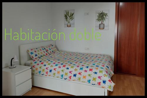 - une chambre avec un lit et un panneau d'aptionote sur le mur dans l'établissement Casa Santa Tecla A Guarda, à A Guarda