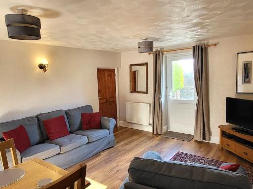 a living room with a couch and a table at Pinfold Cottage on the edge of lake district in Bothel