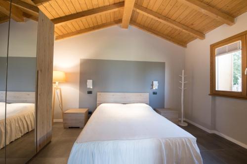 a bedroom with a large white bed and a window at Pieve Del Castello in Deruta