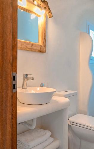 a bathroom with a sink and a mirror and a toilet at Bonzoe #3 in Parikia