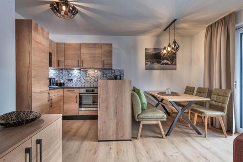 a kitchen and dining room with a table and chairs at AlpenParks Premium Apartment Rehrenberg II in Viehhofen